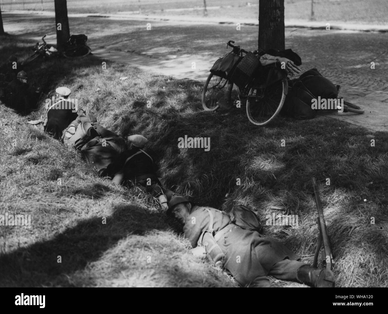 WW2: belgische Soldaten und Flüchtlinge in einem Graben während der Luftangriffe auf der Hauptstraße. Stockfoto