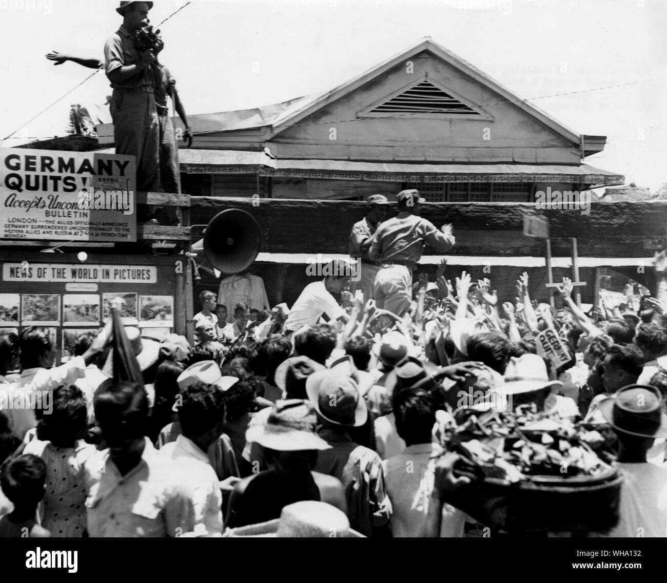 WW2: Die Bewohner der abgelegenen Abschnitte von Manila, Luzon, Masse um eine mobile news Lkw, da es an einer belebten Ecke die bedingungslose Kapitulation Deutschlands bekannt zu geben. 2. Mai 1945. Stockfoto