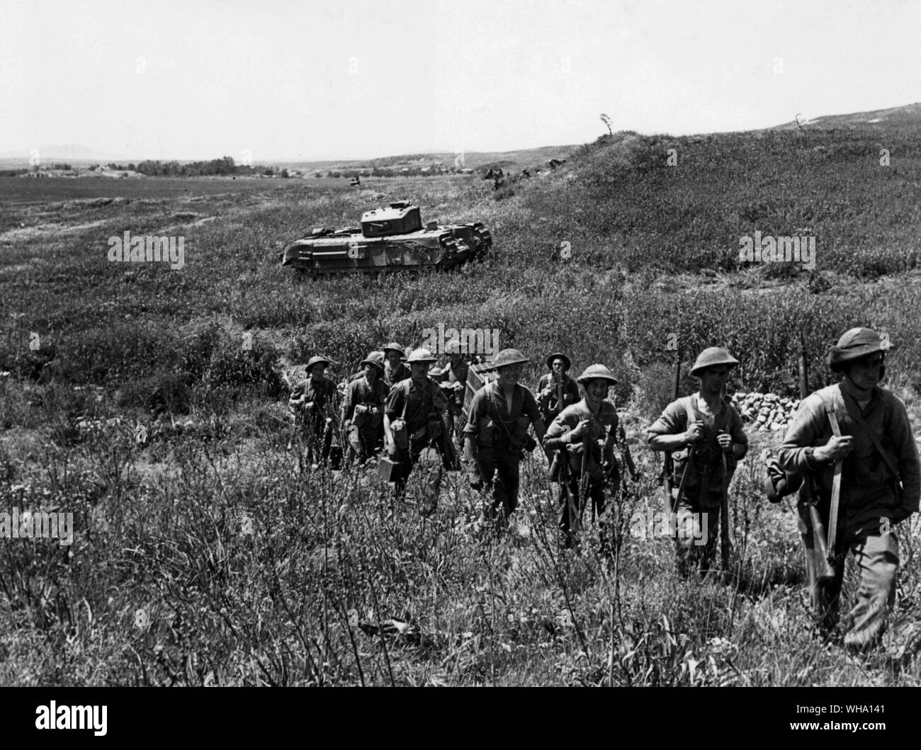 WW2: Nordafrika. Erste Armee Angriff auf Longston Hill, April 1943. Infanterie bewegen bis zu dem Angriff. Im Hintergrund ist einer der Churchill Tanks, die in den Betrieb übernahm. Stockfoto