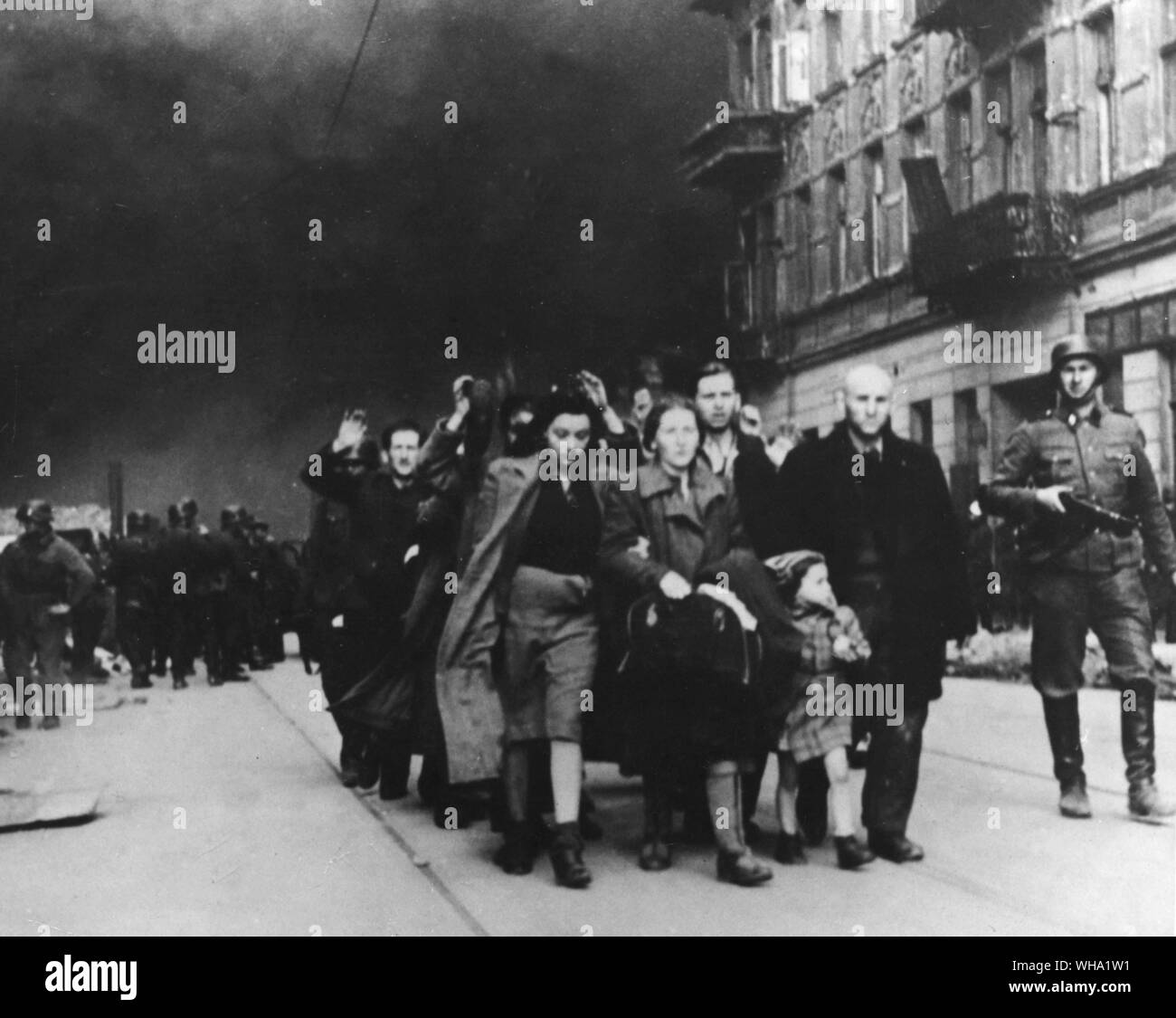 WW2: Dieses Foto wurde als Beweismittel gegen einen deutschen Kommandeur in Warschau, Polen bei der Nürnberger Prozesse im Dezember 1945 verwendet. Polnische menschen marschierten durch die Straßen von deutschen Soldaten. Stockfoto