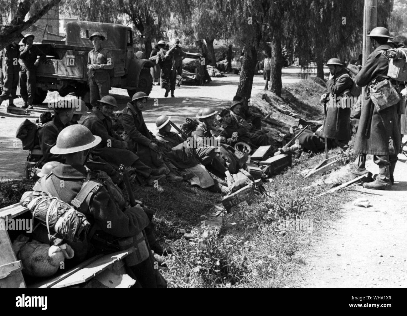 WW2: Britische Truppen ruht in einem strassenrand Graben im Schatten der Pfeffer Bäume, 3. Mai 1941. Griechenland. Stockfoto