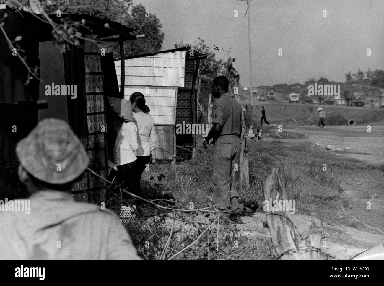 Vietnam-krieg: Soldaten und Mädchen außerhalb der einzelnen Hütten an einem Auto-waschen Lage neben einem langen militärischen Highway. Die Mädchen sind Teil einer Prostitution Schläger. Stockfoto