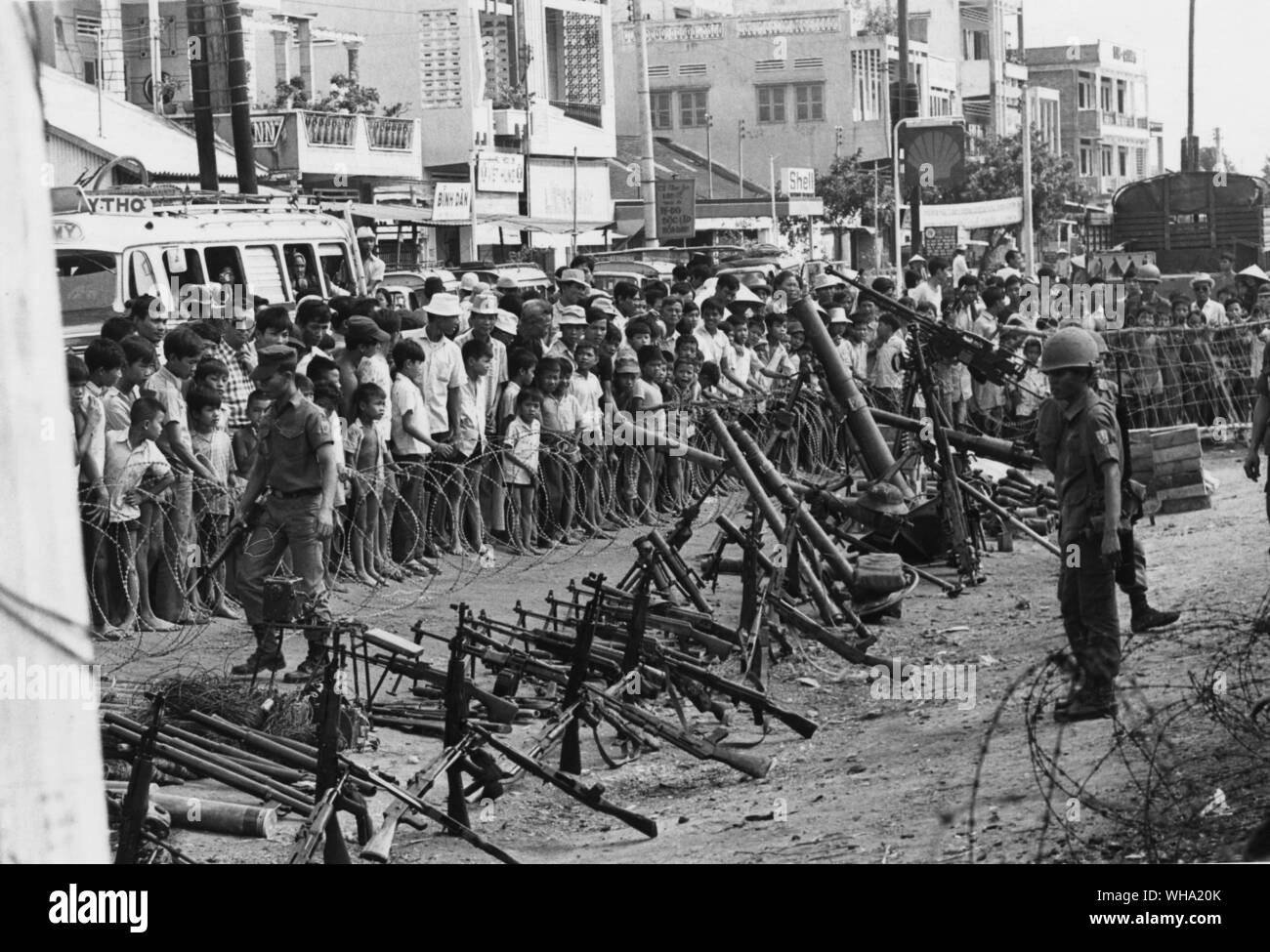 Vietnam-krieg: Vietnaese Soldaten hinter Stacheldraht verbarrikadieren mit Zivilisten auf der Suche. Stockfoto