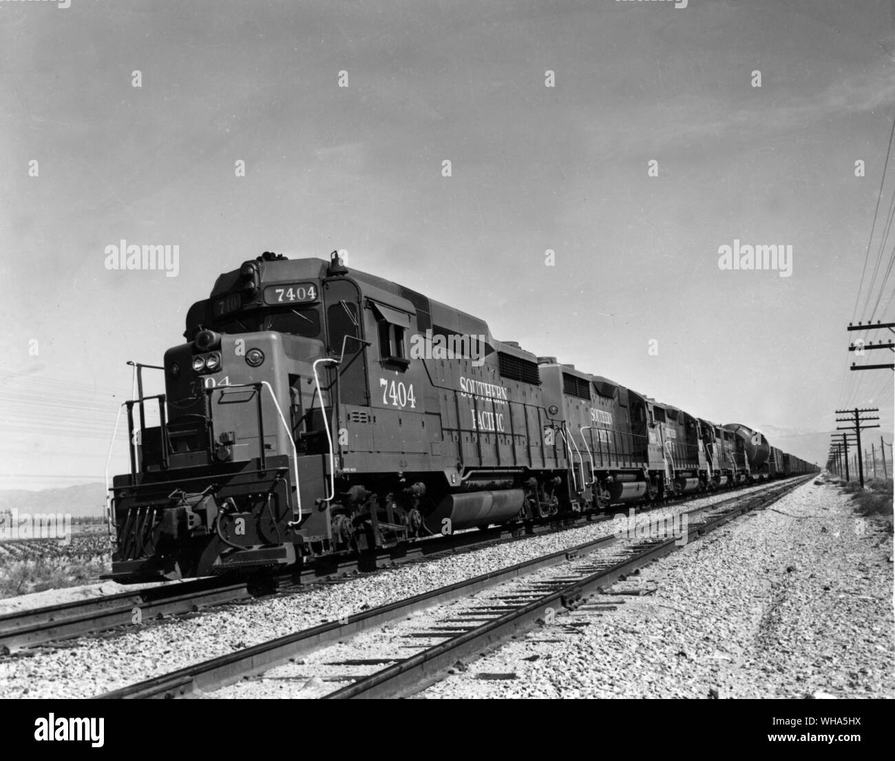 Richtung Westen Southern Pacific Güterzug bei Rochester in Südkalifornien in der Nähe der östlichen Rand der Metropolregion Los Angeles. Extrem hohe und breite Schiff unmittelbar hinter den vier Leitung Lokomotive Einheiten mit diesem Zug. An der Stelle ist Lok 7404, ein General Motors EMD GP-35 Typ Einheit die Entwicklung von 2250 PS und 1963 erbaut Stockfoto