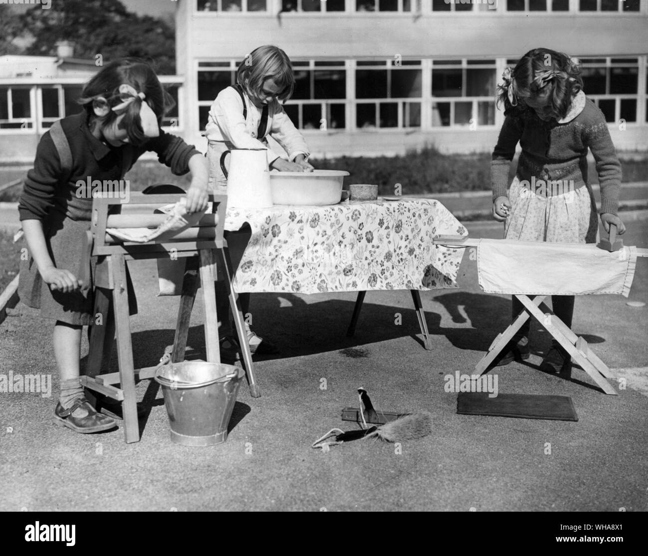 Obere Tulse Hill Kinder Schule in Brixton, wo Kiddies angeregt werden konstruktive Aktivität mit Spielen zu kombinieren. Diese kleinen Mädchen tun makebeieve Hausarbeit. Sie sind Janet Frankel an der Wringer, Linda Weedon waschen, und Elaine Kirche bügeln.. 7. Oktober 1952 Stockfoto