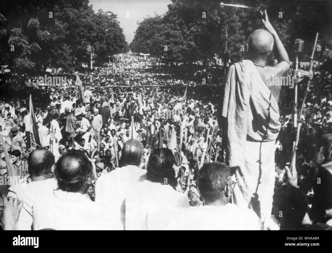 Ein Sadhu (hinduistische heilige Mann) steht neben anderen sadhus und Adressen eine amtlich geschätzten Masse von 125.000 Anhängern, bevor Sie außerhalb des Parlaments Gebäude in New Delhi Indien gezeigt, 7. November 1966 fordert ein Verbot der Schlachtung von Kühen. Stockfoto