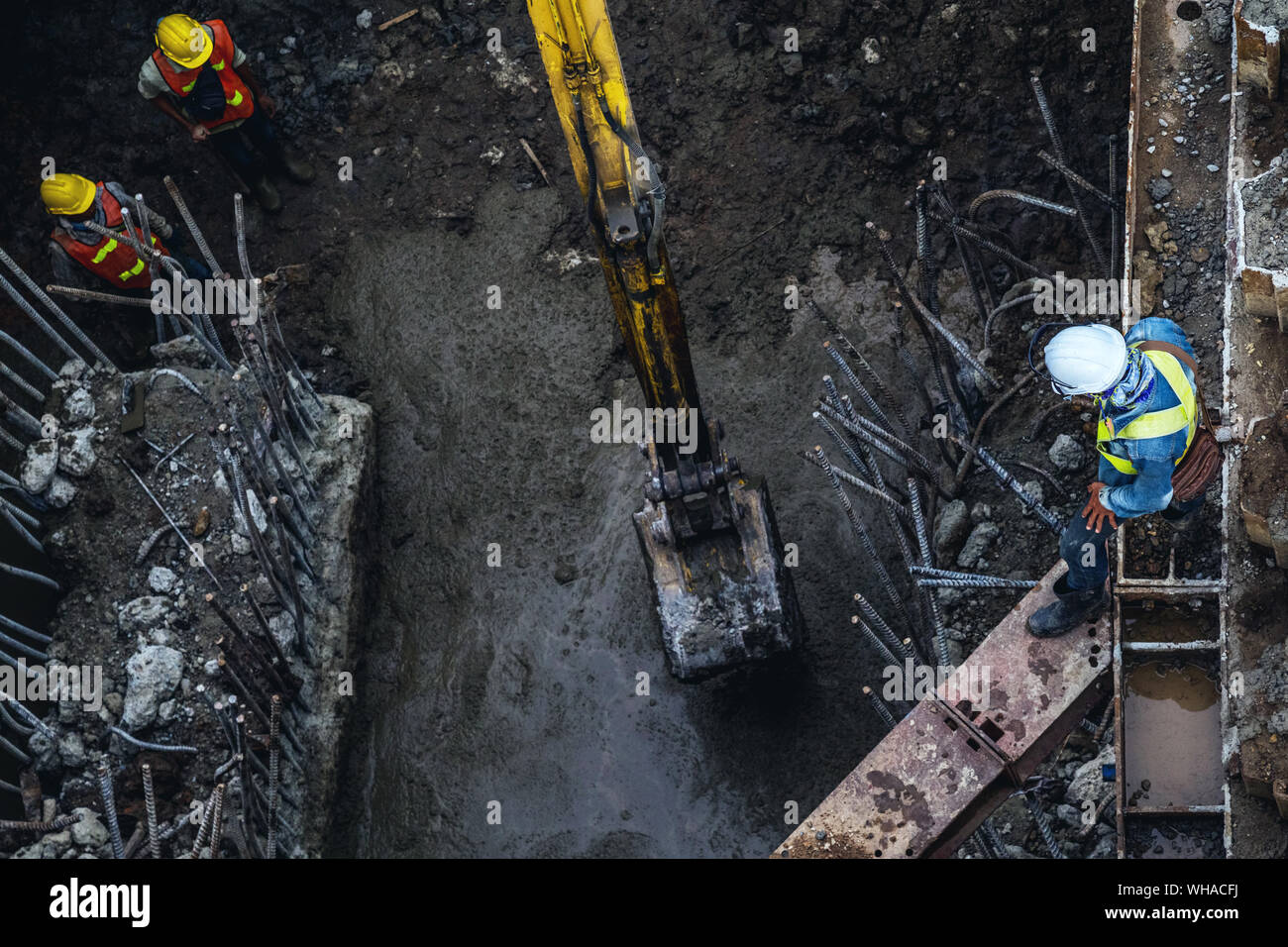 Asiatische Arbeiter Bauarbeiter und Bagger Baggerlader arbeiten für Basis-Stiftung vor Ort für eine neue Route Sky train Bau in Bangkok, Thail Stockfoto