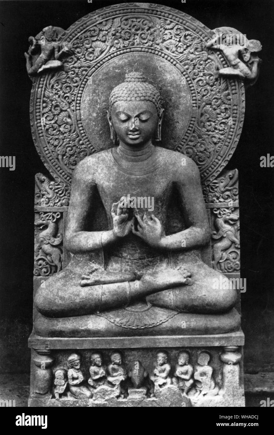 Der Buddha sitzt im Schneidersitz auf einem Lotus Thron mit Händen in der Lehre Geste. Unter ihm ist das Rad des Dharma, dass er Rollen. Sandstein Skulptur von Sarnath Indien. Neu Delhi Stockfoto