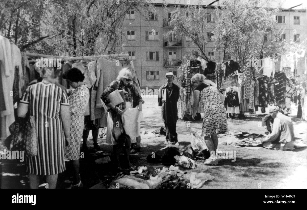 Kabul, 14. Juli 1980. Russen kaufen Amerikanische. Die ehefrauen der Russischen Offiziere und Beamte shop für second hand American Clothing an einem speziellen Basar auf dem Rasen vor dem Apartment Komplex im Microrayon, wo Sie leben. Gebrauchte Kleider sind eine von Amerikas größten Ausfuhren in Afghanistan Stockfoto