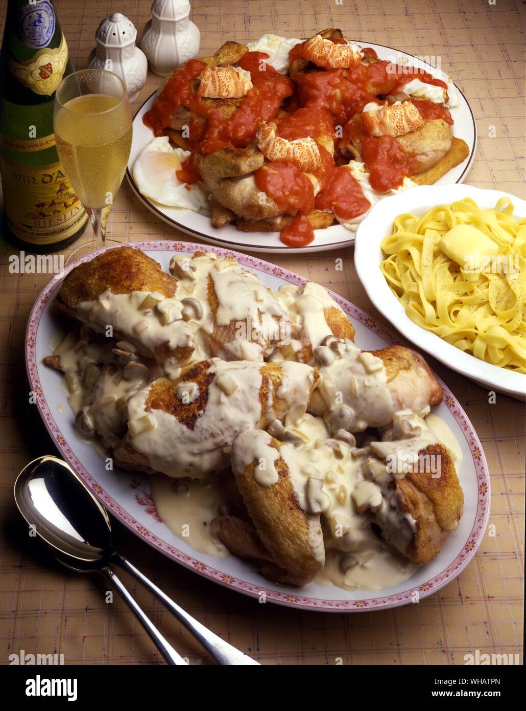 Internationale Küche. Top Huhn Marengo.. Frankreich oder Italien. Unten, Alsace-Style Coq au Vin.. Saute Coq Au Riesling, Frankreich. Stockfoto