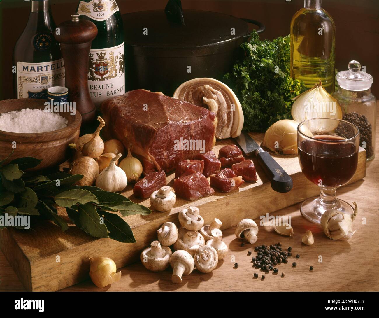 Fleisch, Pilze, Zwiebeln und Knoblauch auf einem Brett. Stockfoto