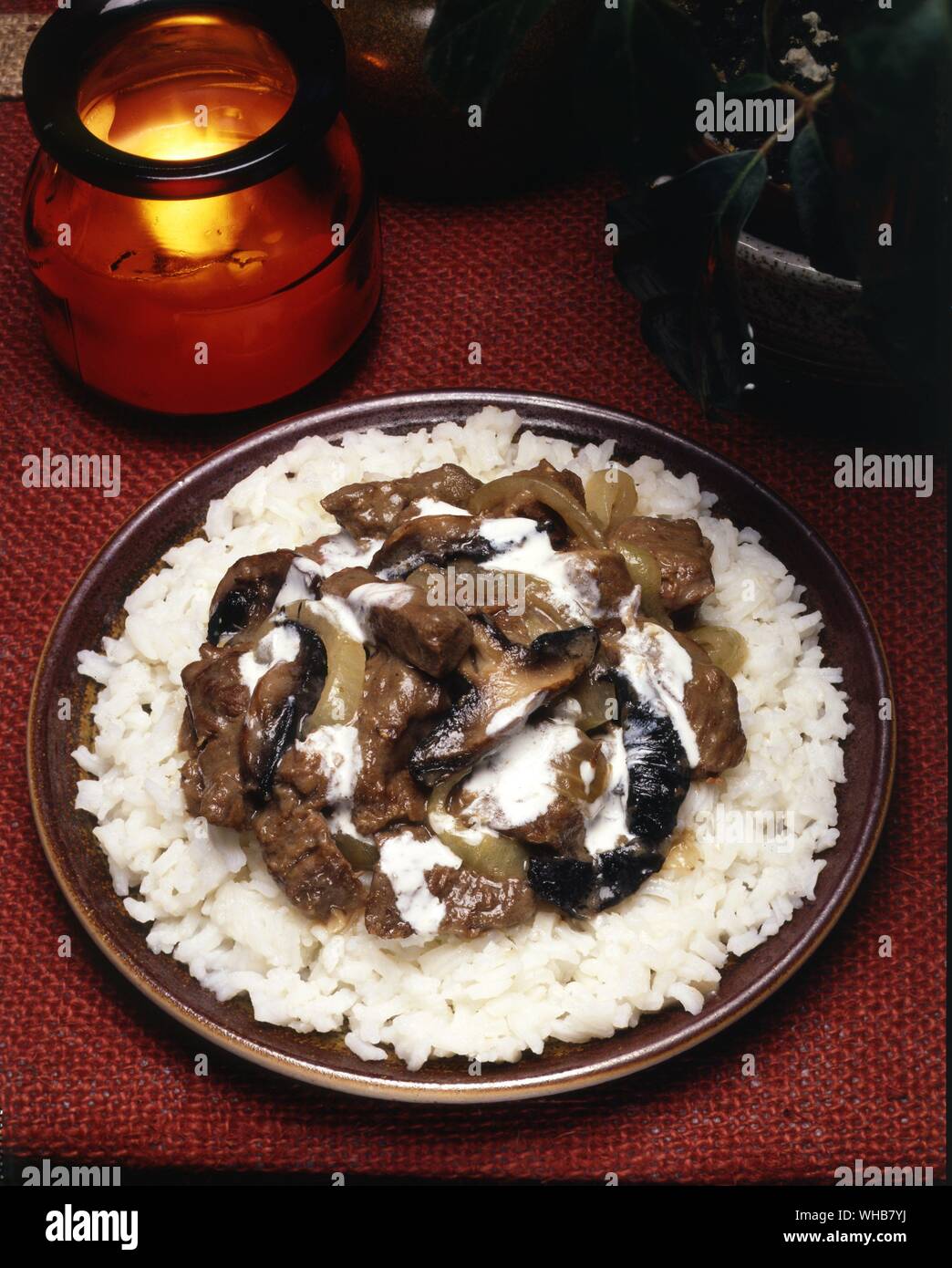 Streifen von Fleisch, Zwiebeln, Pilzen und Sahne auf einem Bett aus Reis.. Stockfoto