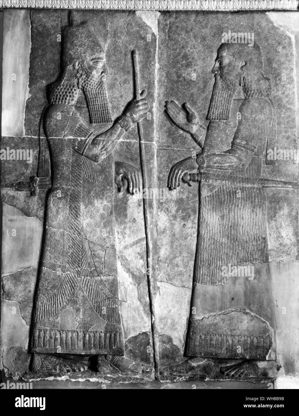 Aus dem Palast von Sargon II. von Assyrien: Bas Relief zeigt den König mit einem Stab in der rechten Hand und Rücksprache mit einem seiner Beamten Stockfoto