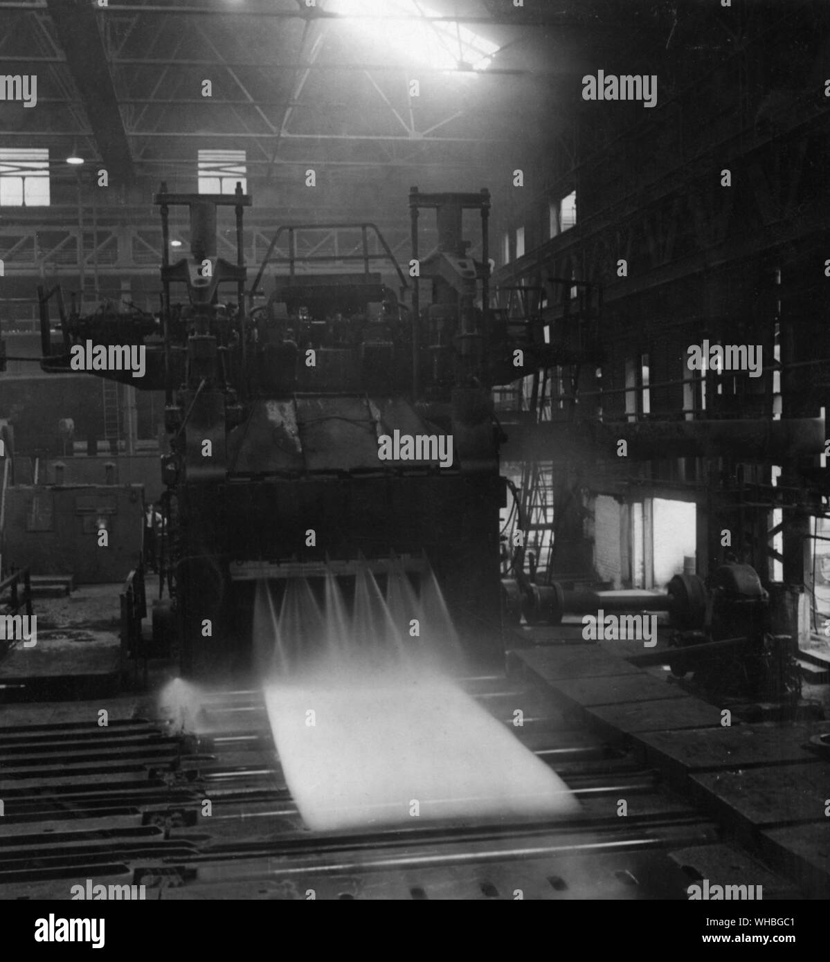 Weiße heiße Schiffe Platte durch die Platte Mühlen an der Appleby Frodingham Stahl arbeitet in Scunthorpe Lincolnshire, England. Das Wasser spritzt aus dem Oxid Skala zu waschen. 1948 Stockfoto
