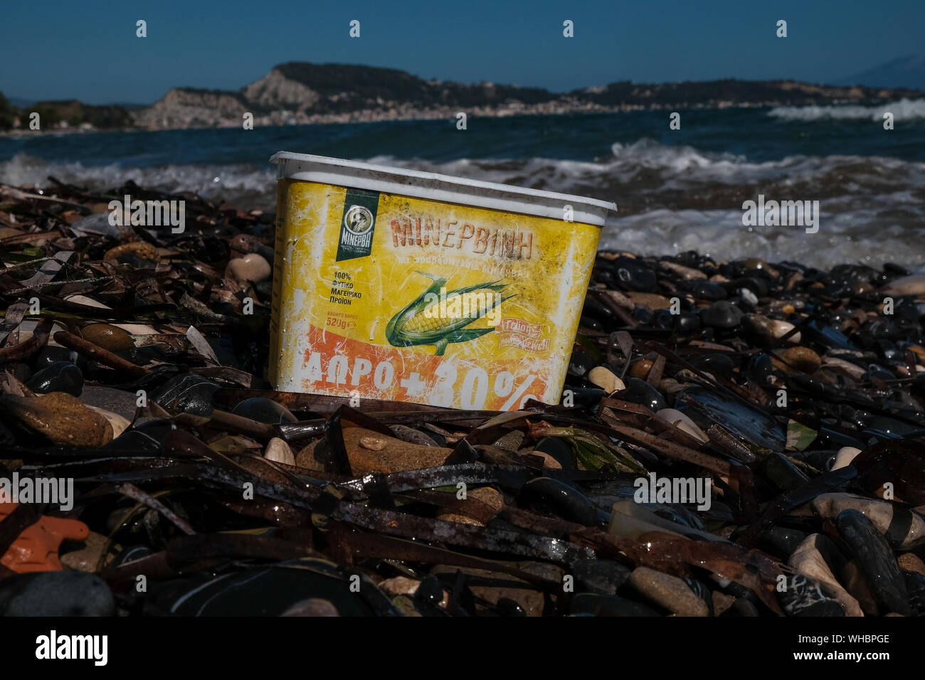 Ein Kunststoff Zuckermais Container entsorgt am Strand mit Wasser Ausbleichen und Schäden, die in den jetzt die Verschmutzung der Meere und der Umwelt schaden. Stockfoto