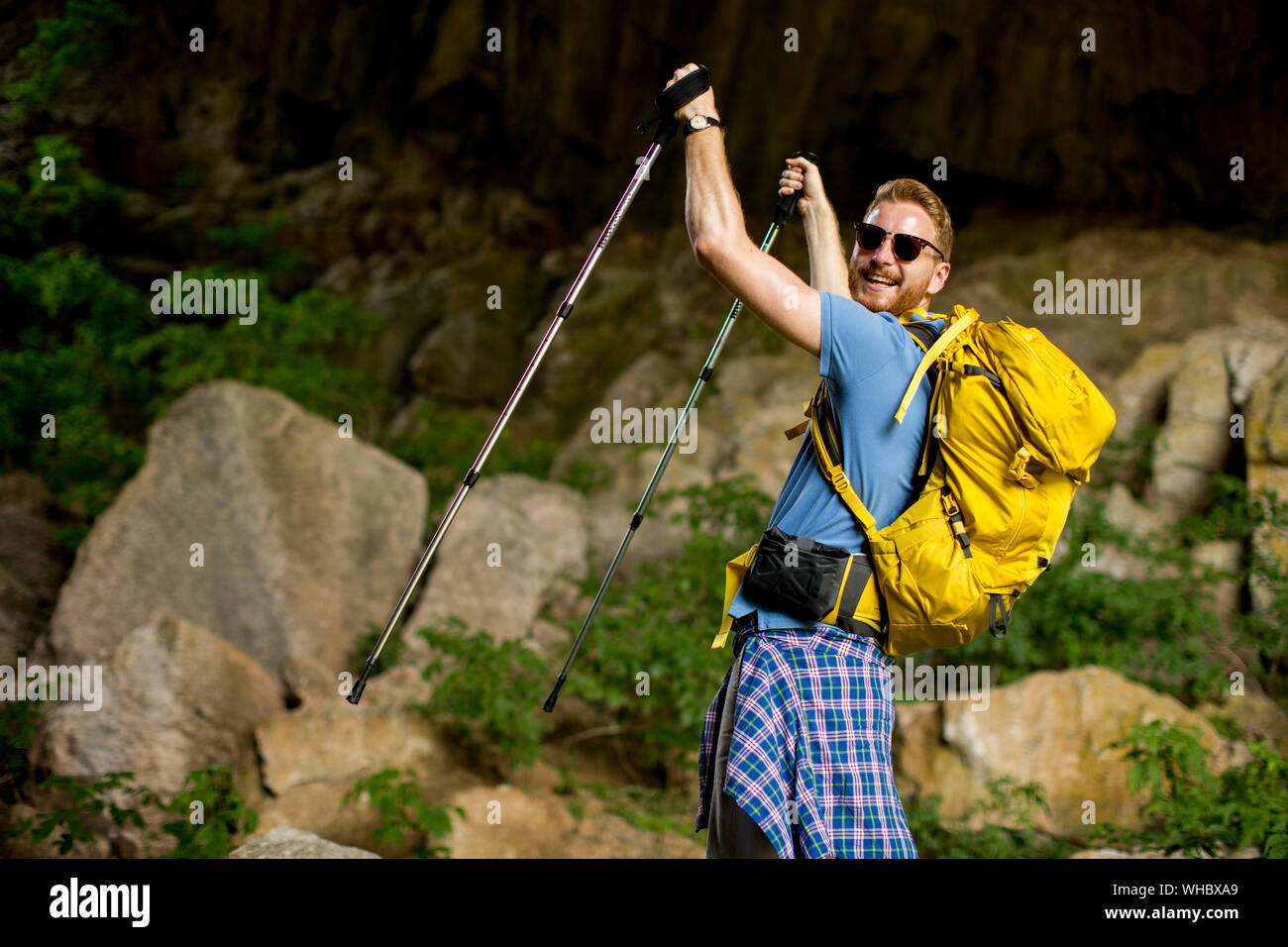 Anmutige junge Kaukasier Männlich Wanderer mit Rucksack wandern an einem sonnigen Tag Stockfoto
