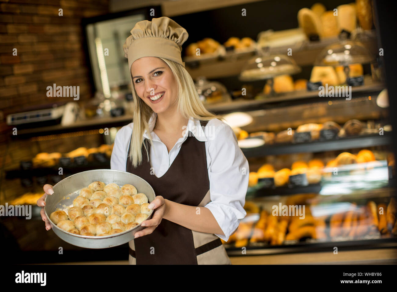 Porträt der jungen Frau mit Korb mit Gebäck an ihre Bäckerei freudig lächelnd in die Kamera Stockfoto