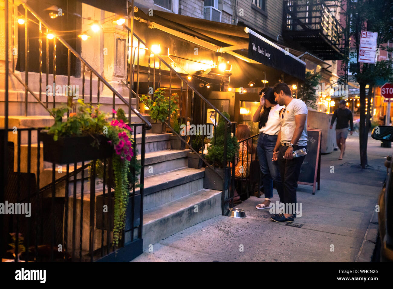 NEW YORK CITY - 24. AUGUST 2019: Outdoor Restaurant street Szene aus dem West Village in Manhattan mit Menschen speisen an einem Samstag Abend. Stockfoto