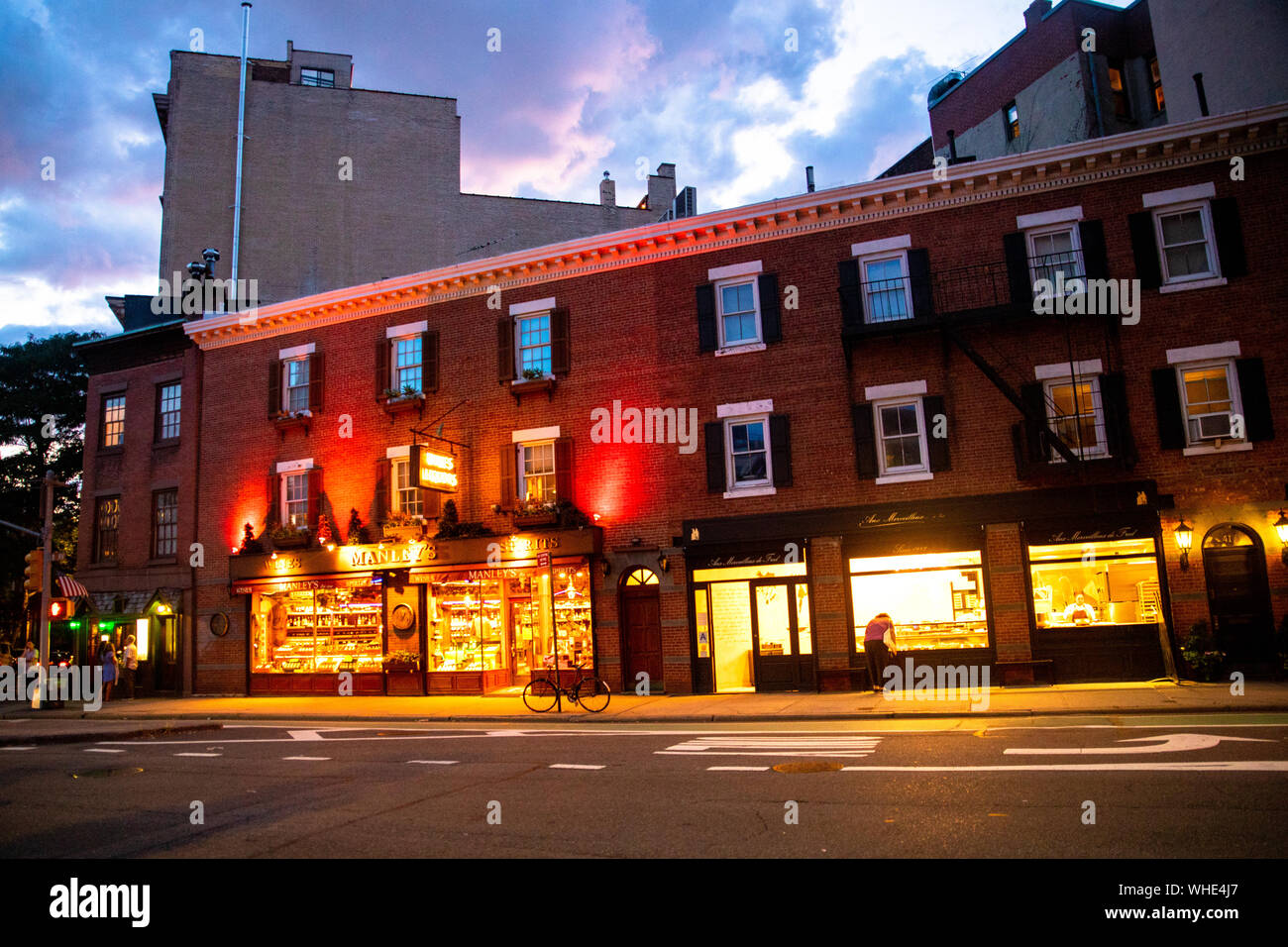 NEW YORK CITY - 24. AUGUST 2019: Street Scene mit Geschäften, Lichter, Menschen und Autos, die in der Nacht von Greenwich Village, West Village Manhattan gesehen. Stockfoto