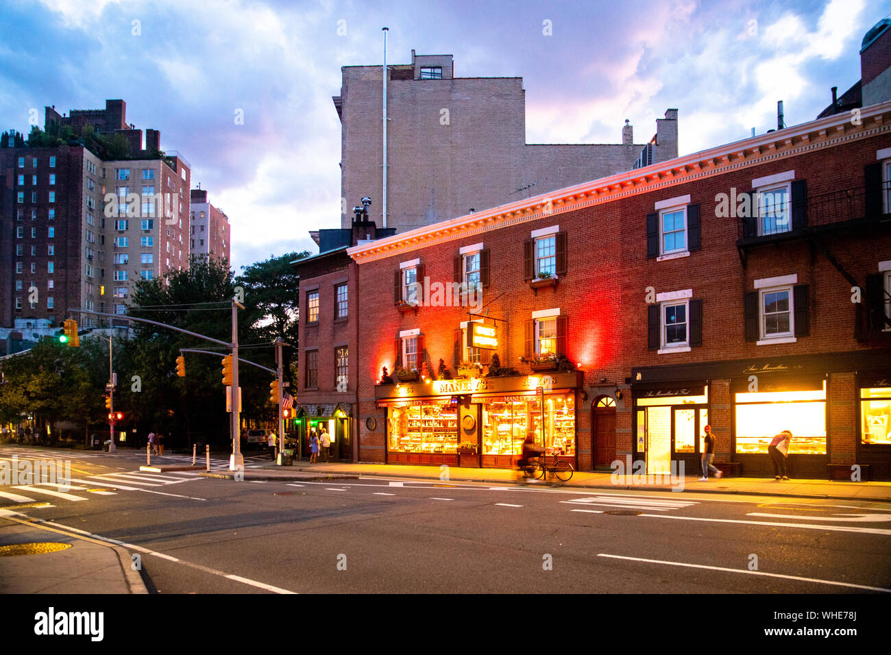 NEW YORK CITY - 24. AUGUST 2019: Street Scene mit Geschäften, Lichter, Menschen und Autos, die in der Nacht von Greenwich Village, West Village Manhattan gesehen. Stockfoto