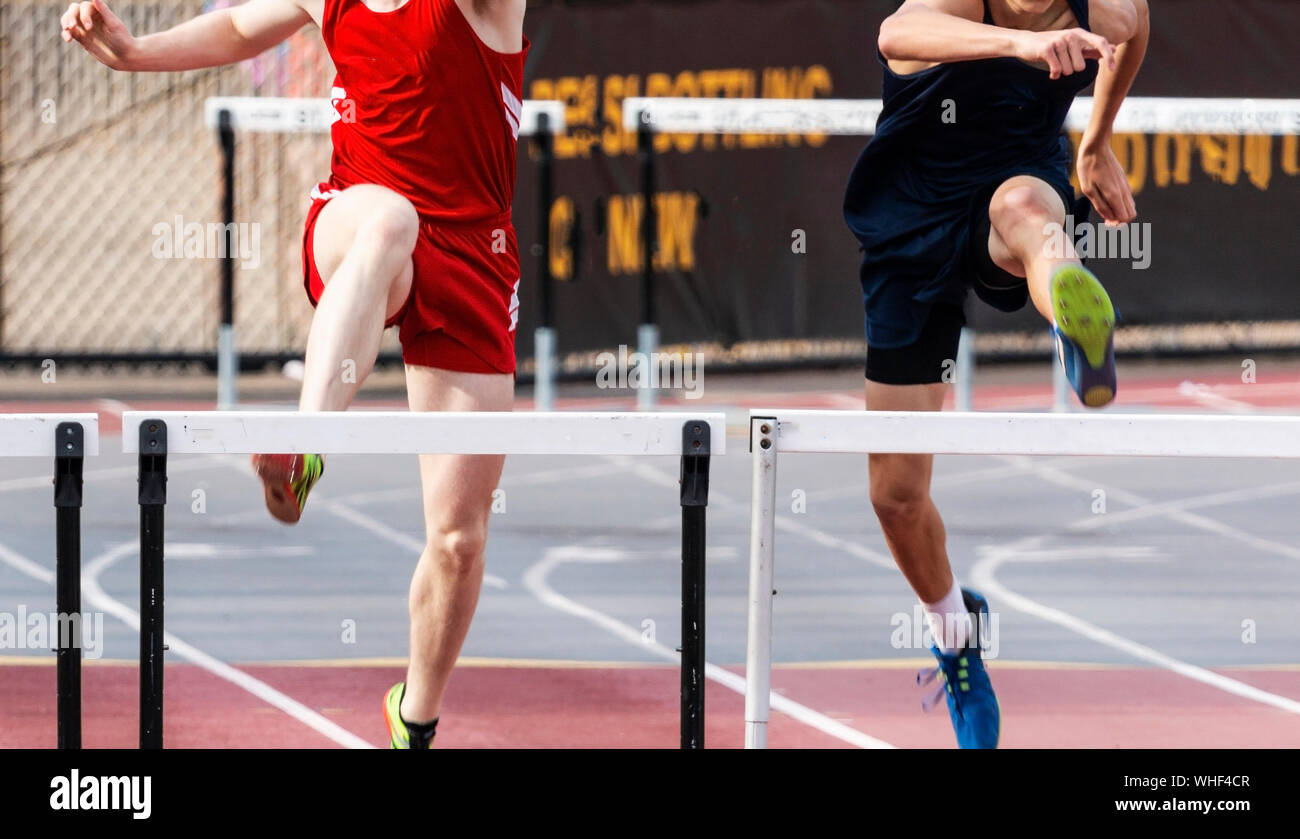 Zwei High School Jungen sind in den 400 Meter Hürden Rennen der letzten alsbald gebunden. Stockfoto