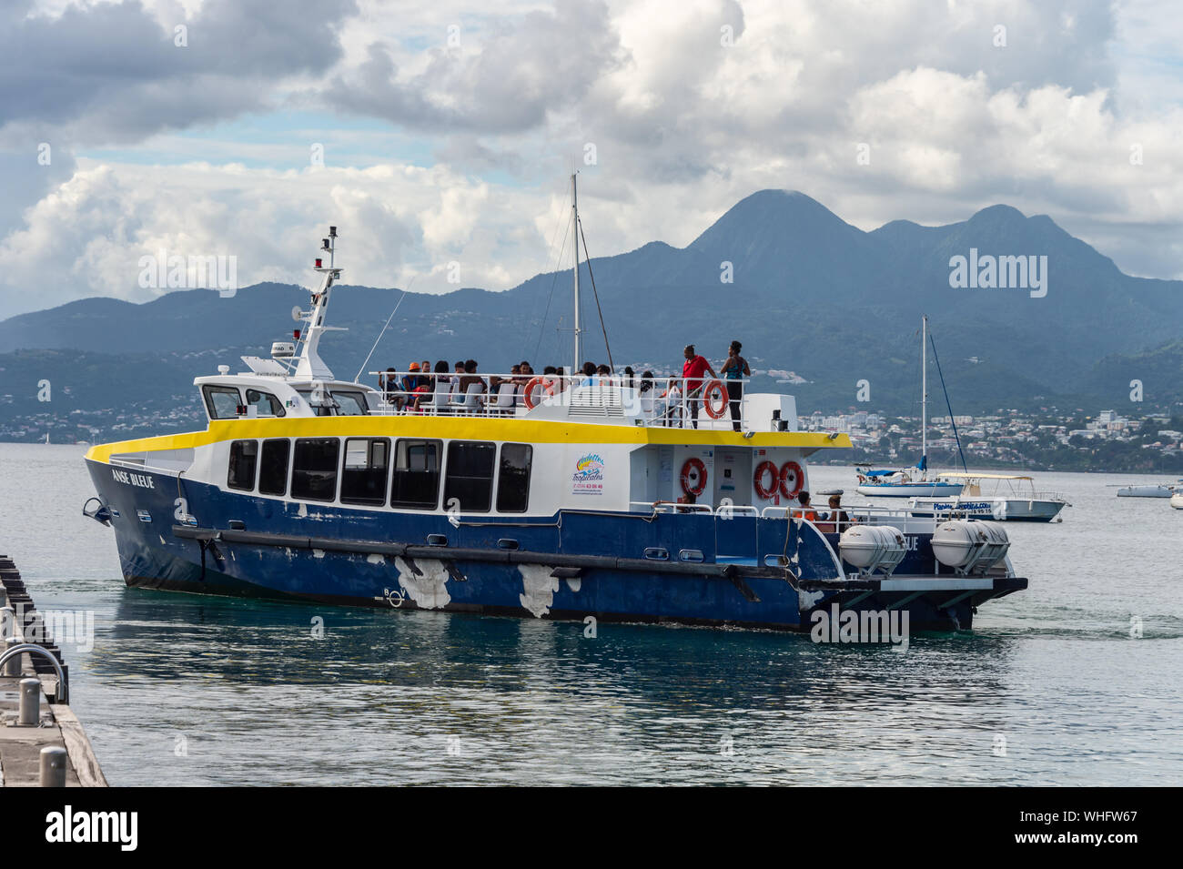 Anse-à-l'âne, Martinique, Frankreich - 21 August 2019: Shuttle boatgoing nach Fort-de-France, mit Montagne Pelée Vulkan im Hintergrund. Stockfoto