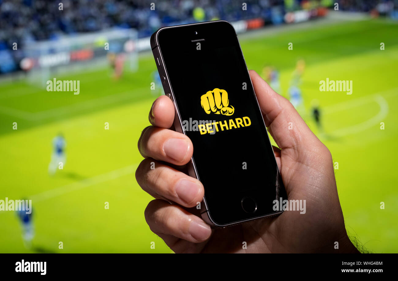 Ein Mann auf der Suche an der Wette Hart app-Webseite, während gerade der Fußball Stockfoto