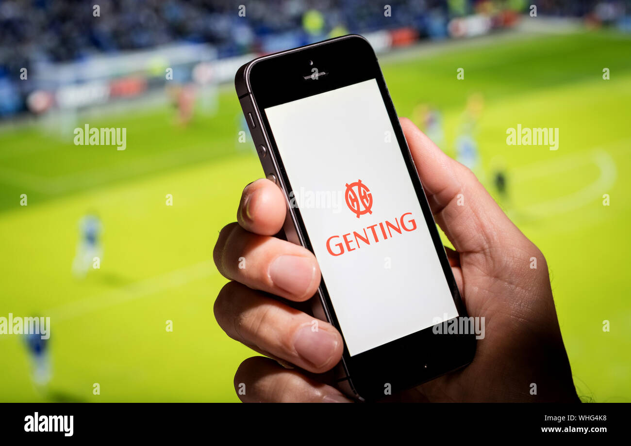 Ein Mann, der an das Genting Wetten auf der Suche app-Webseite, während gerade der Fußball Stockfoto