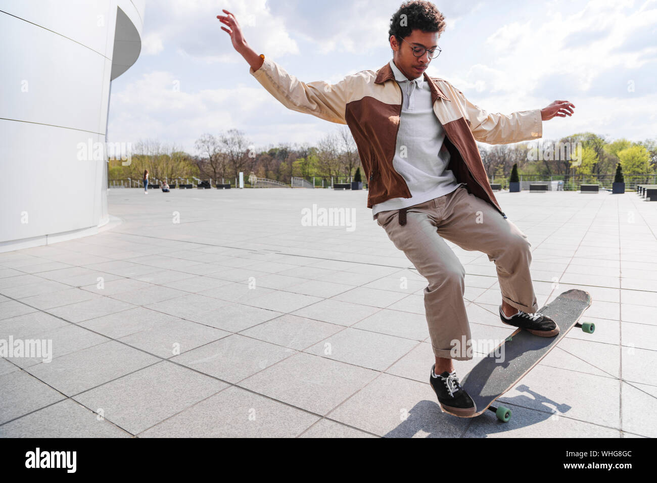 Afro Skateboarder hat Ollie vor Gebäude Stockfoto