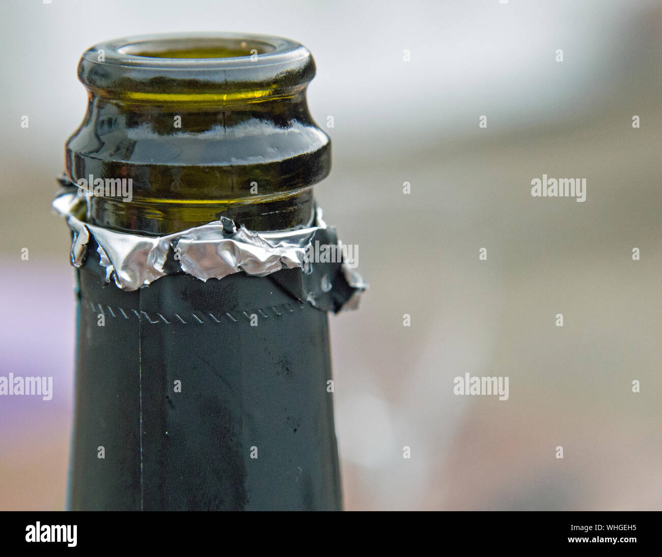 Nahaufnahme auf grünem Glas Sekt Flasche Mund mit Metallfolie abgeschält Stockfoto