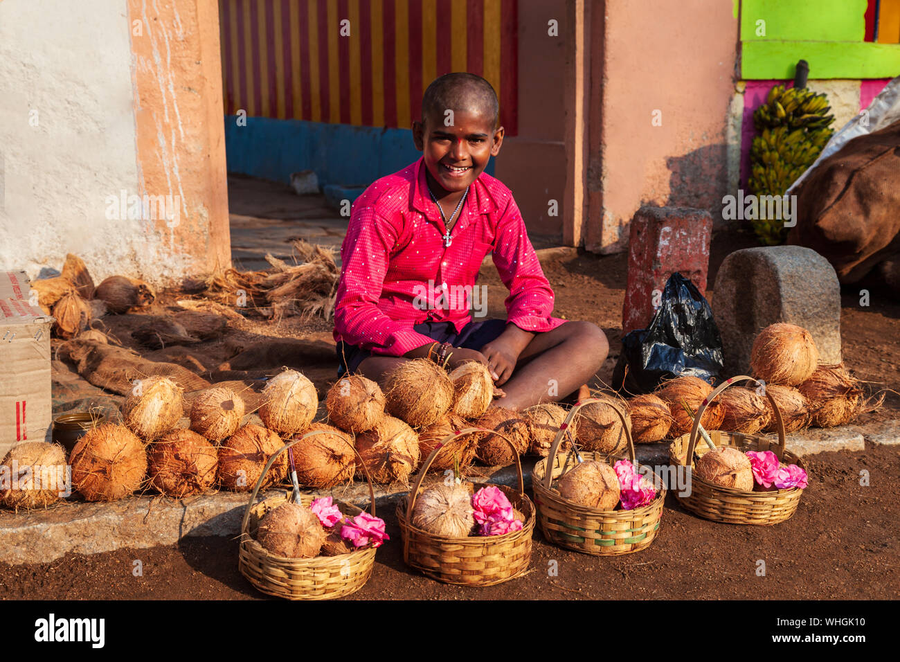 HAMPI, INDIEN - 21. FEBRUAR 2012: Nicht identifizierte junge Verkauf coconut Angebote für Holi Puja in Delhi, Indien Stockfoto