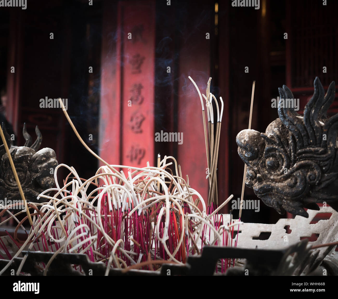 Rauchen Buddhistische Räucherstäbchen vor roten Pagode mit chinesischen Zeichen, Tempel der Literatur, Hanoi, Vietnam Stockfoto