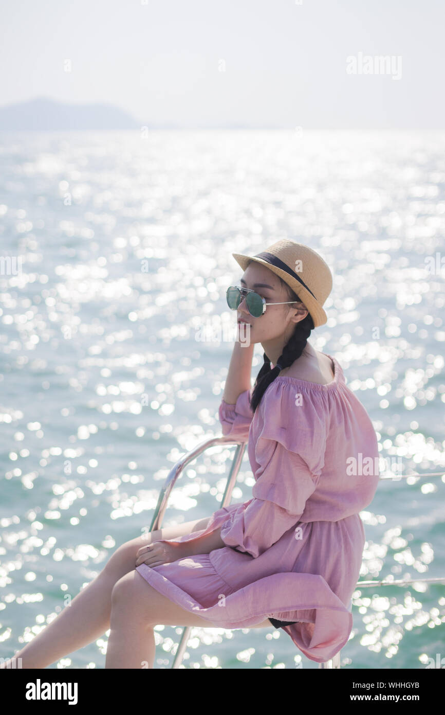 Seitenansicht der jungen Frau sitzt auf der nautischen Behälter gegen Meer Stockfoto