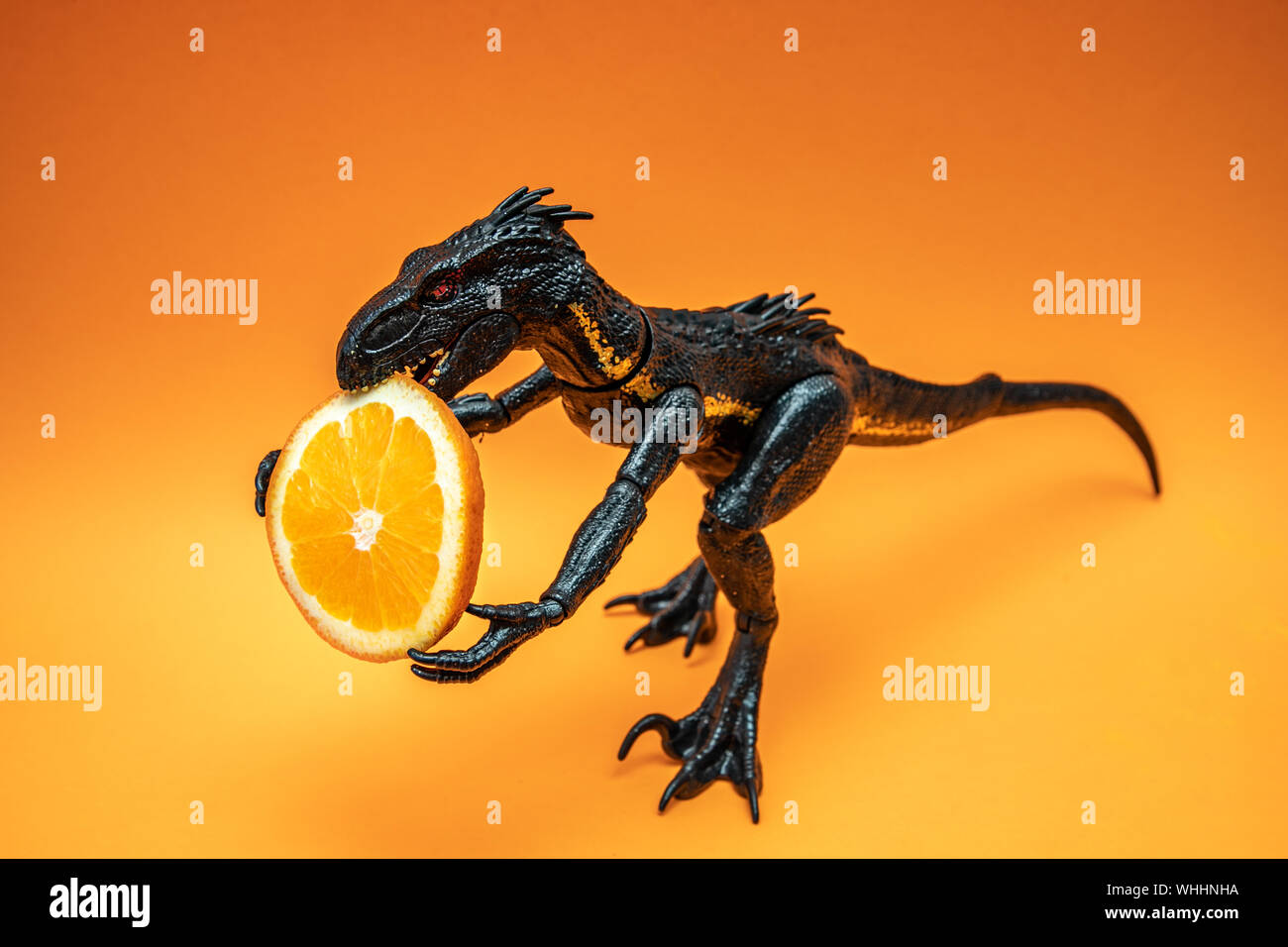 Schwarz Dinosaurier mit Scheibe von Kalk, auf orange Hintergrund isoliert, kopieren Platz für Text oder border Design Stockfoto
