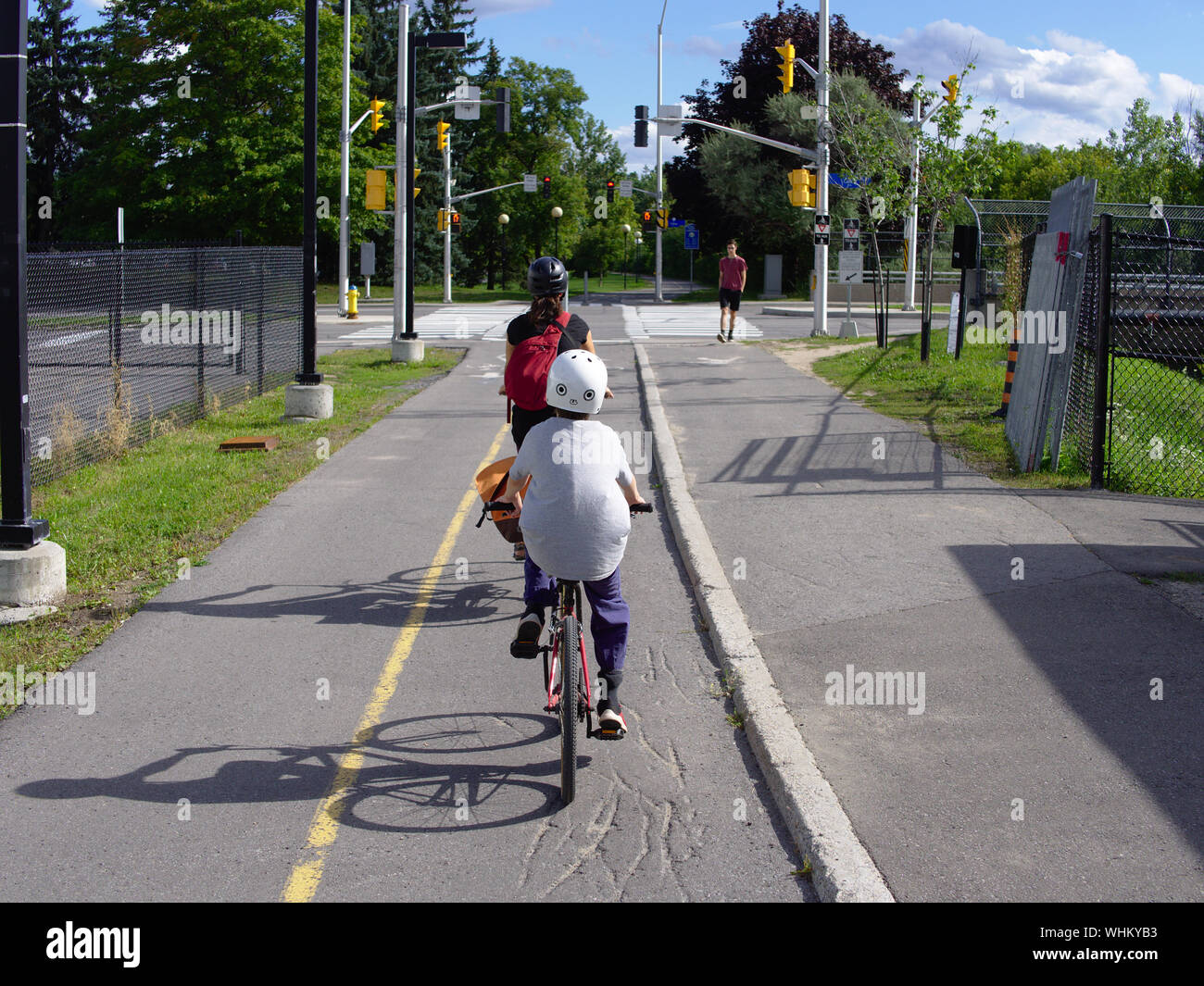 Radfahrer (Mutter und Sohn) in Richtung Süden auf der Trillium Radweg, nähert sich Carling Avenue Kreuzung, Ottawa, Ontario, Kanada. Stockfoto