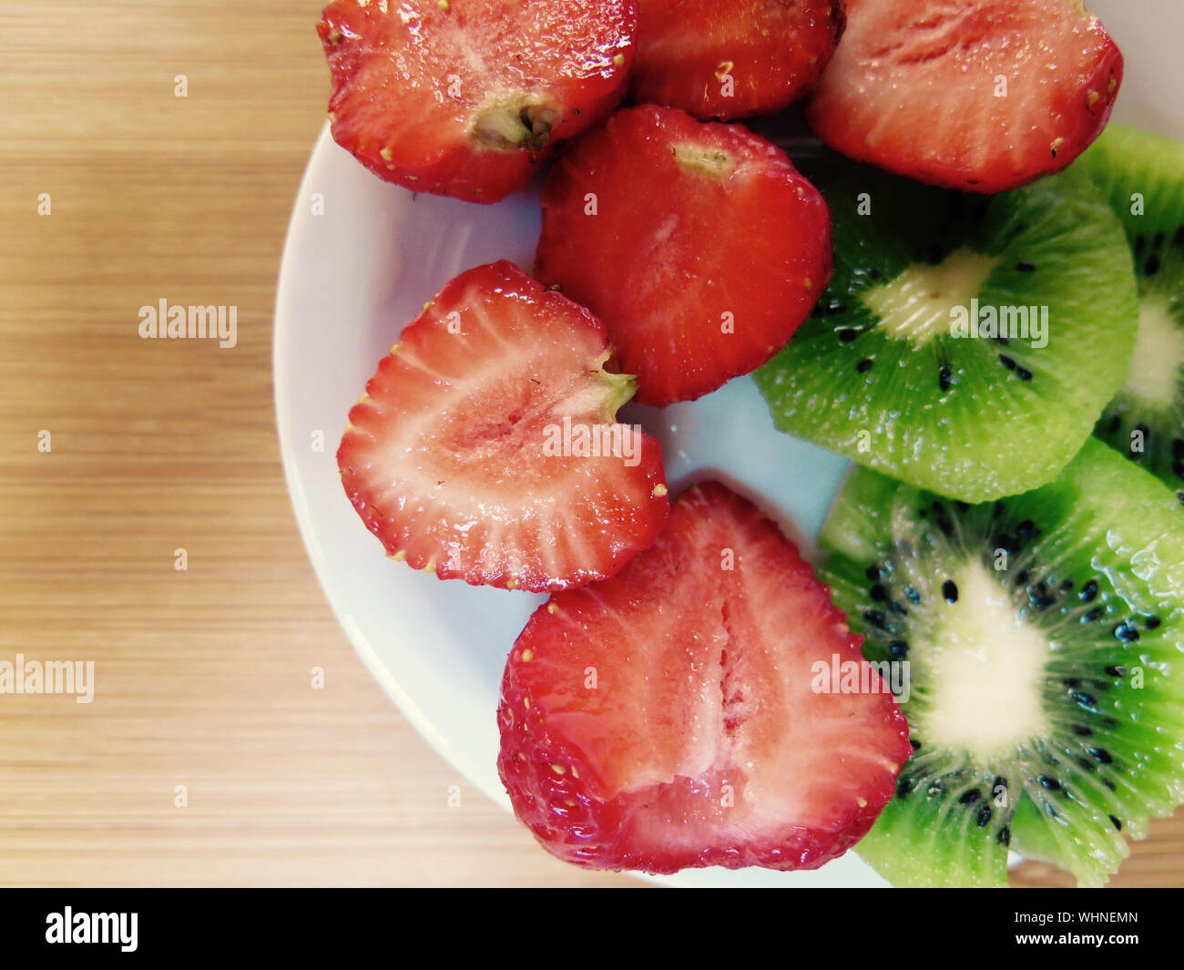 Scheiben von Erdbeeren und Kiwis In der Platte auf dem Tisch Stockfoto