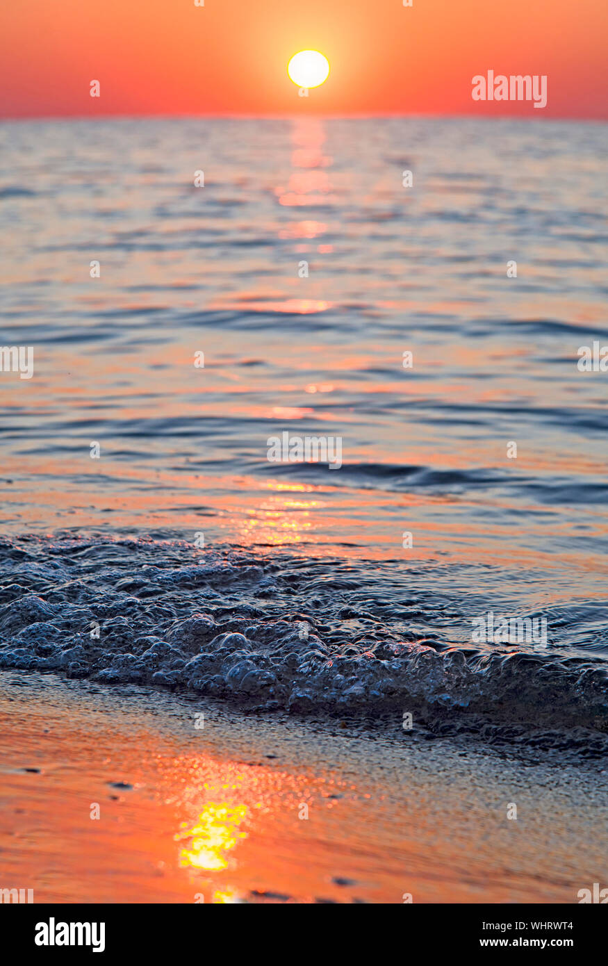 Helle Sonnenuntergang mit großen, gelben Sonne unter der Meeresoberfläche Stockfoto