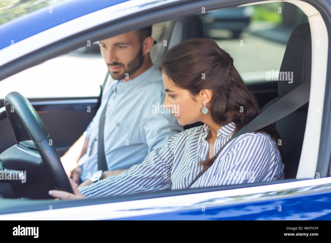 Dunkelhaarige Frau tragen gestreifte Bluse Auto Stockfoto