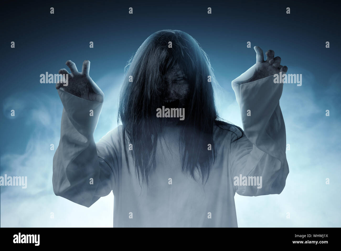Beängstigend ghost Frau mit Blut und wütend das Gesicht mit Kratzen Hände stehen inmitten der dunklen Nebel. Halloween Konzept Stockfoto