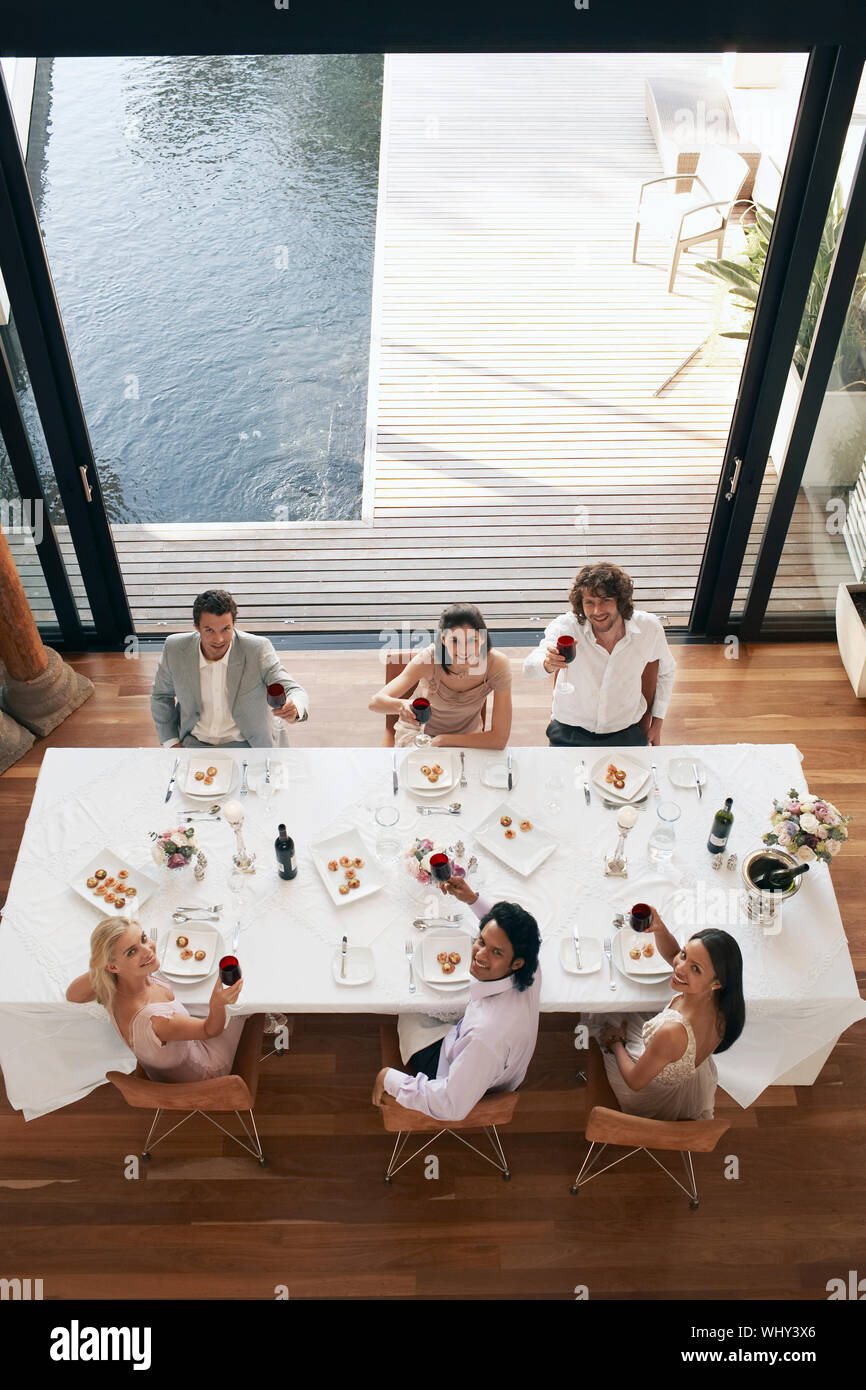 Hohen winkel Portrait von Multiethnischen Freunde toasten Wein zum Abendessen Partei Stockfoto