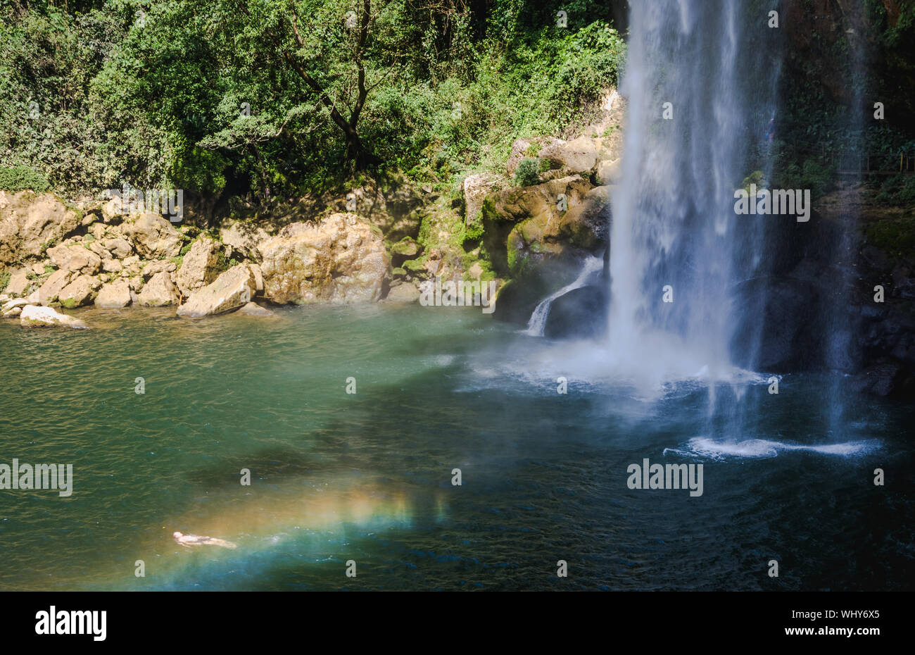 Misol-Ha Wasserfall und Mann Schwimmen im Regenbogen, Chiapas, Mexiko. Stockfoto