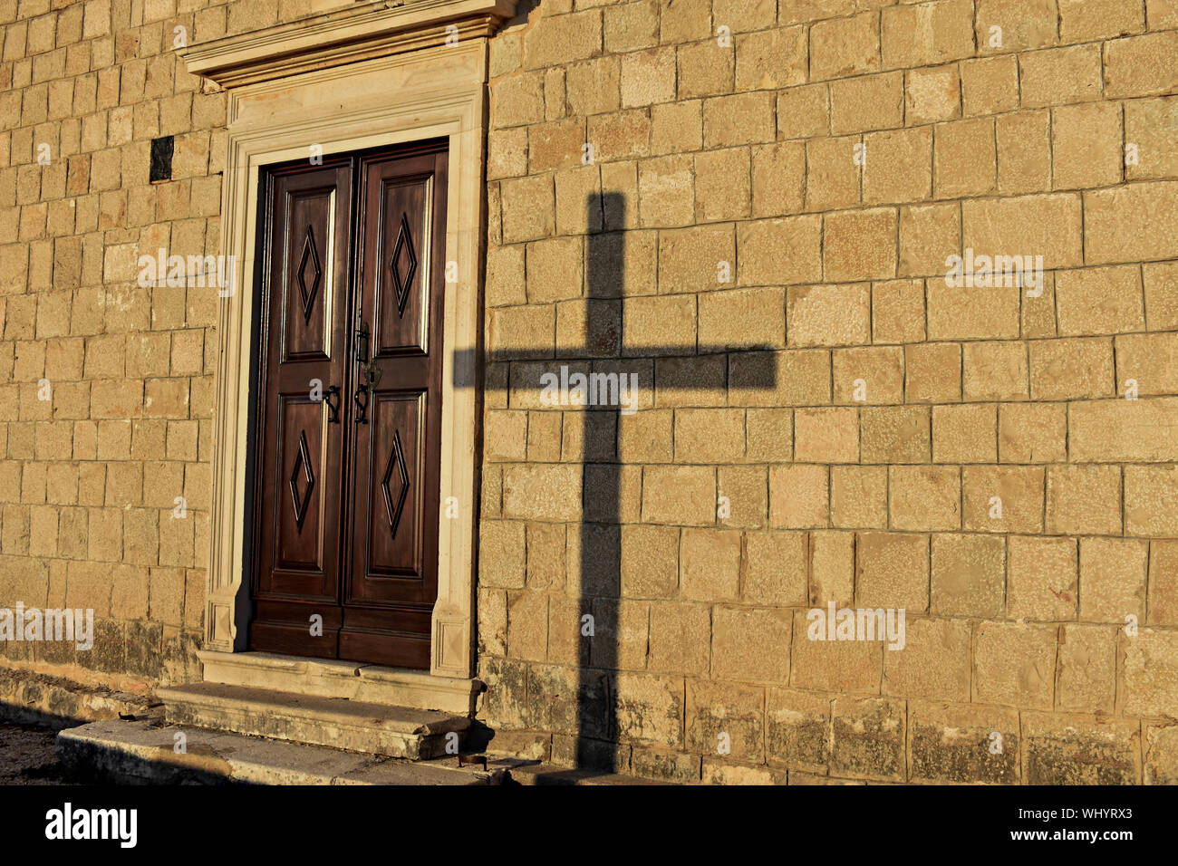 Schatten eines religiösen Kreuz auf der Kirche an der Wand Stockfoto