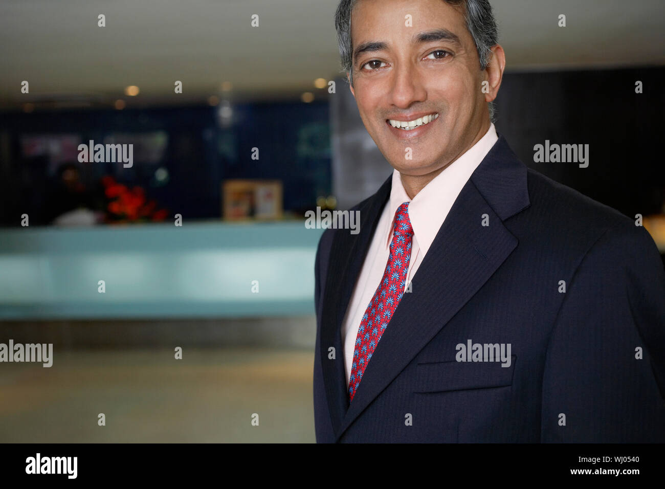 Portrait von glücklich im mittleren Alter Geschäftsmann in der Hotellobby Stockfoto