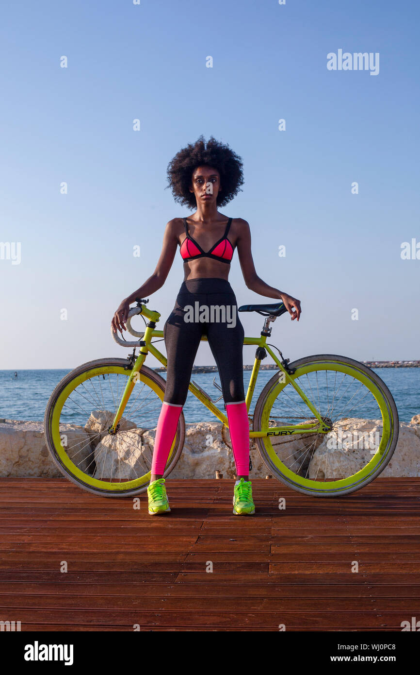Junge athletische Frau im Sport Kleidung mit Ihrem Rennrad in der Nähe des Meeres Stockfoto