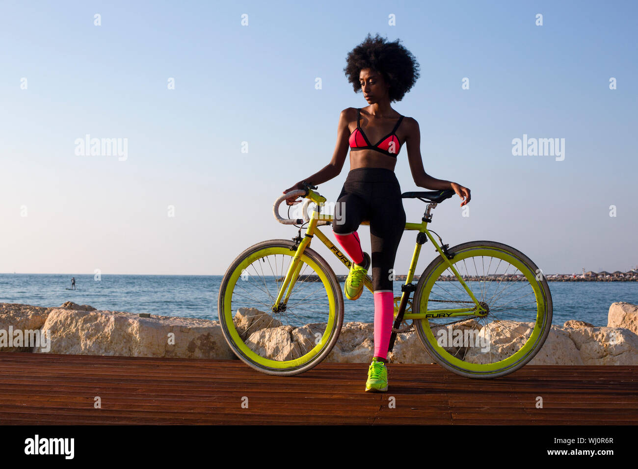 Junge athletische Frau im Sport Kleidung mit Ihrem Rennrad in der Nähe des Meeres Stockfoto