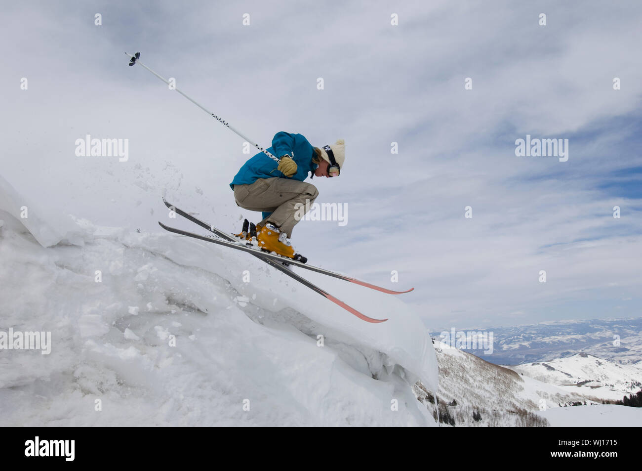 Skifahrer, die eisigen Überhang abspringen Stockfoto