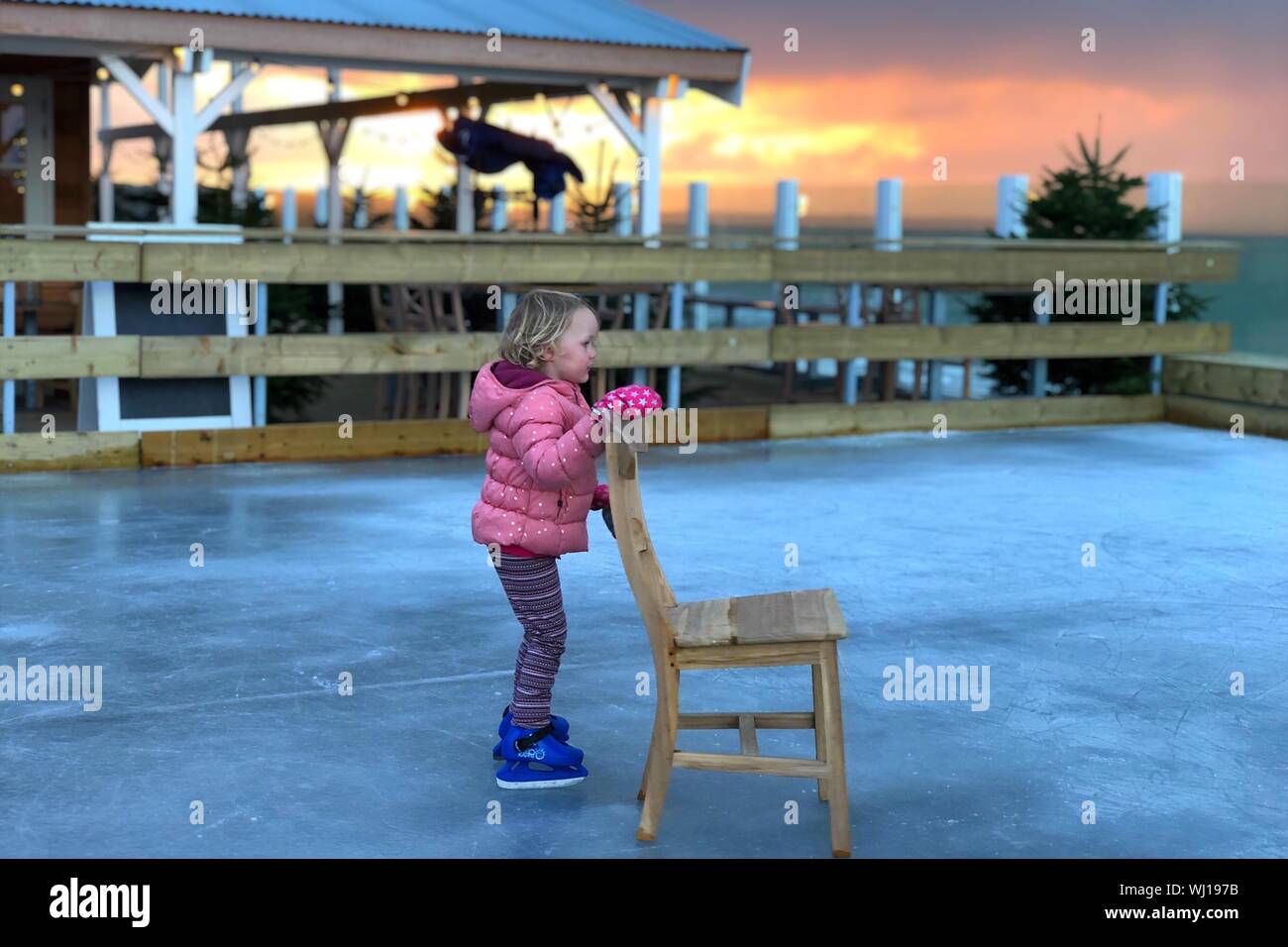 Mädchen, dass Stuhl beim Schlittschuhlaufen auf der Eisbahn Stockfotografie  - Alamy