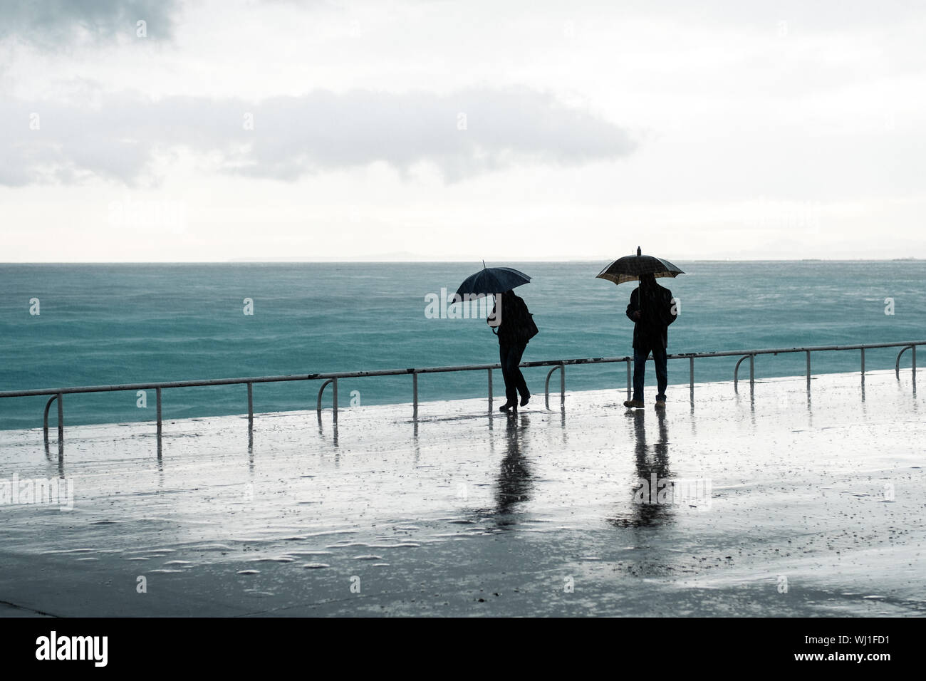 Silhouette Menschen Mit Regenschirm Zu Fuss Am Strand Gegen Himmel Wahrend Monsun Stockfotografie Alamy