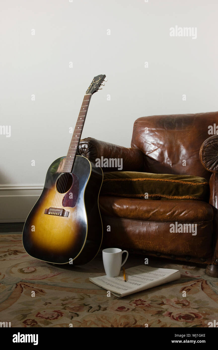 Gitarre mit Kaffeetasse und Noten gegen Leder Sessel Stockfotografie - Alamy
