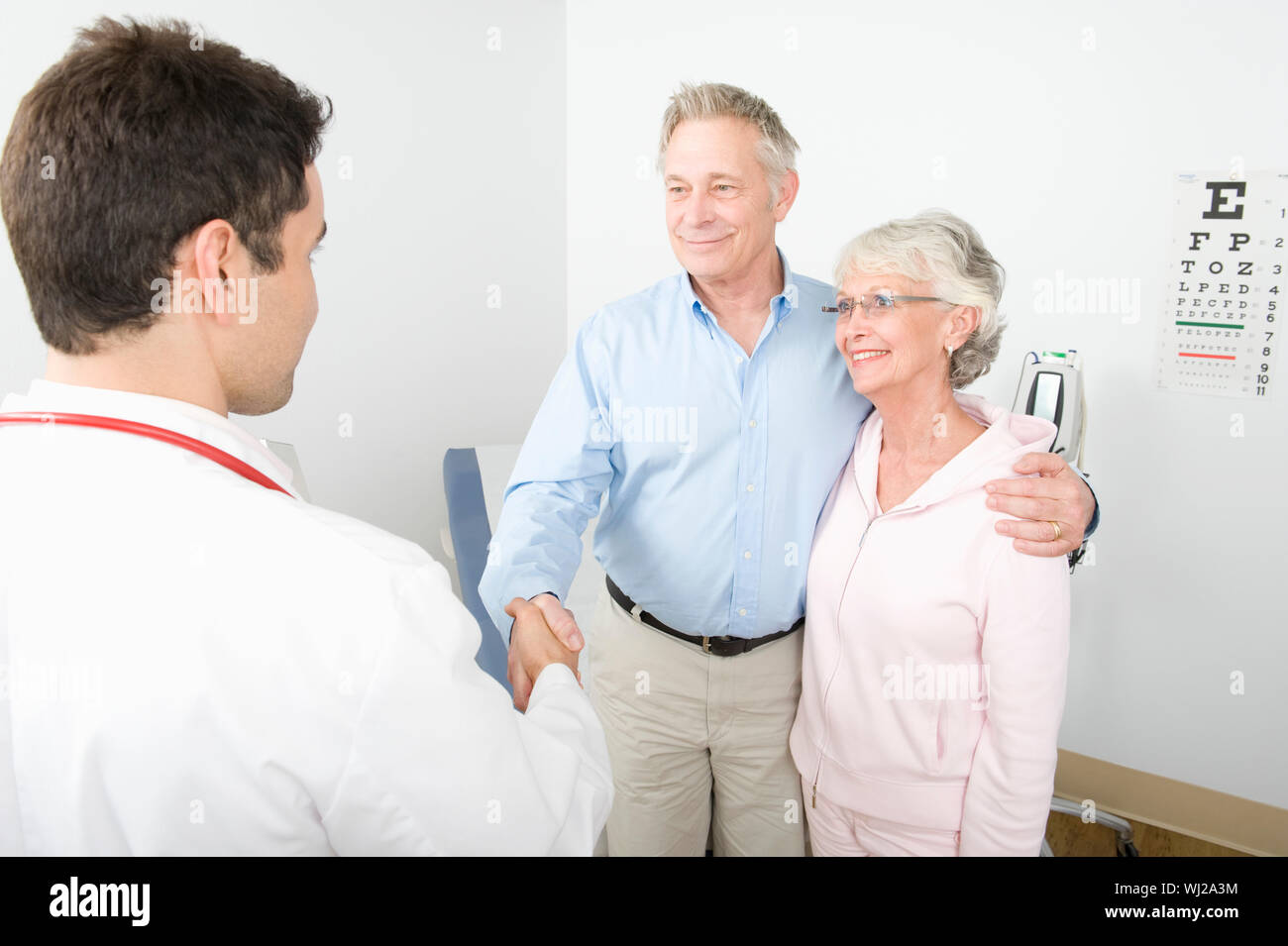 Ein dankbarer älterer männlichen stehen neben Frau Hände schütteln mit dem Arzt in der Klinik Stockfoto